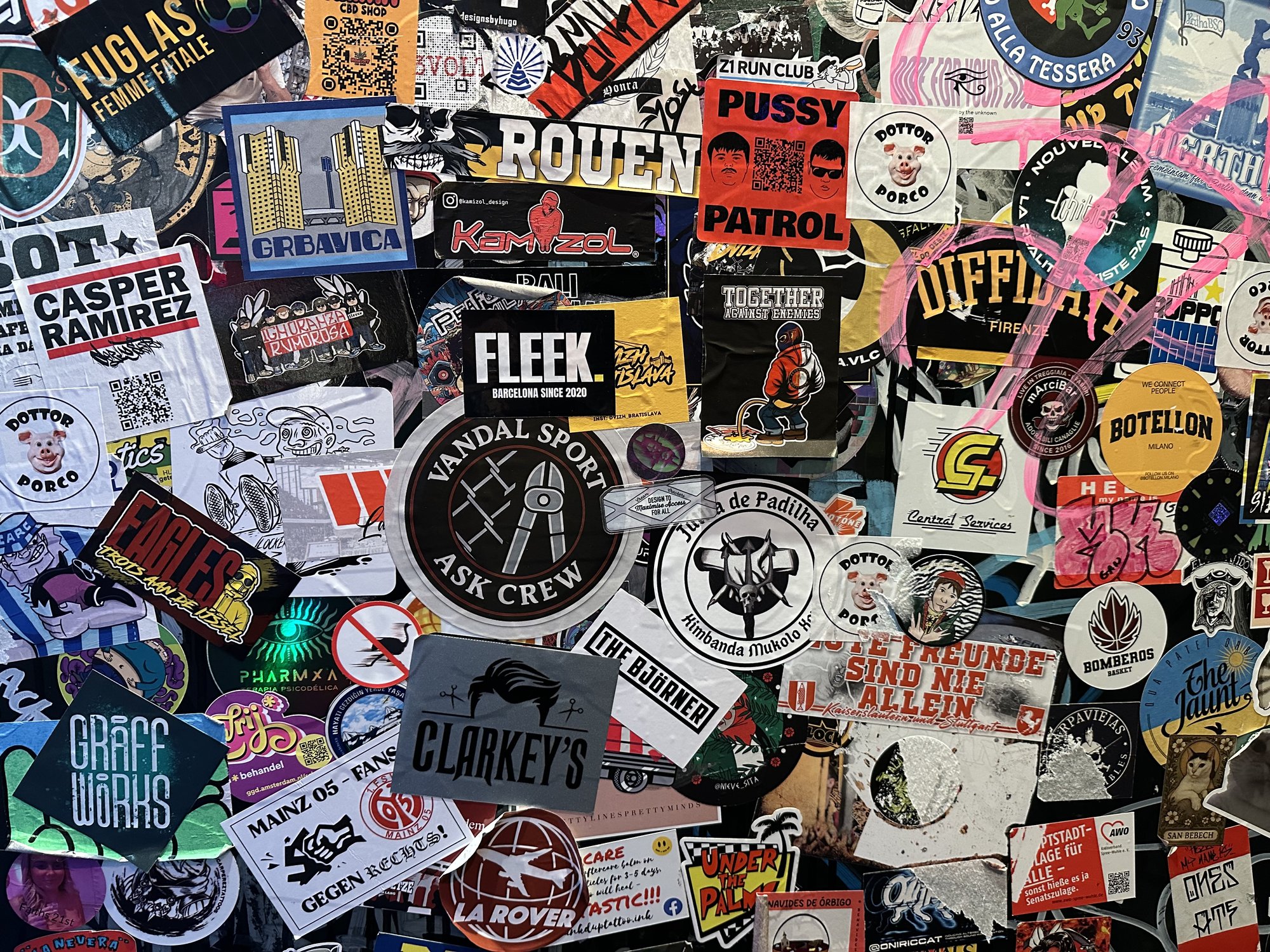 A dense layered wall of stickers