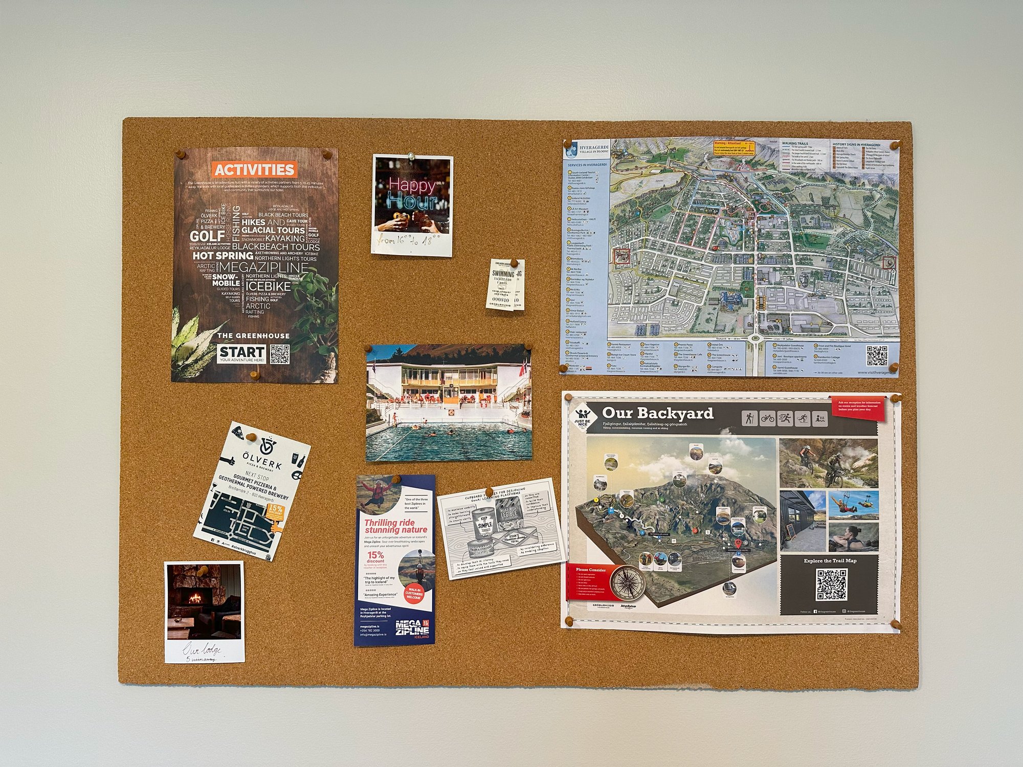 Heuristics postcards pinned to a cork noticeboard alongside local maps and leaflets