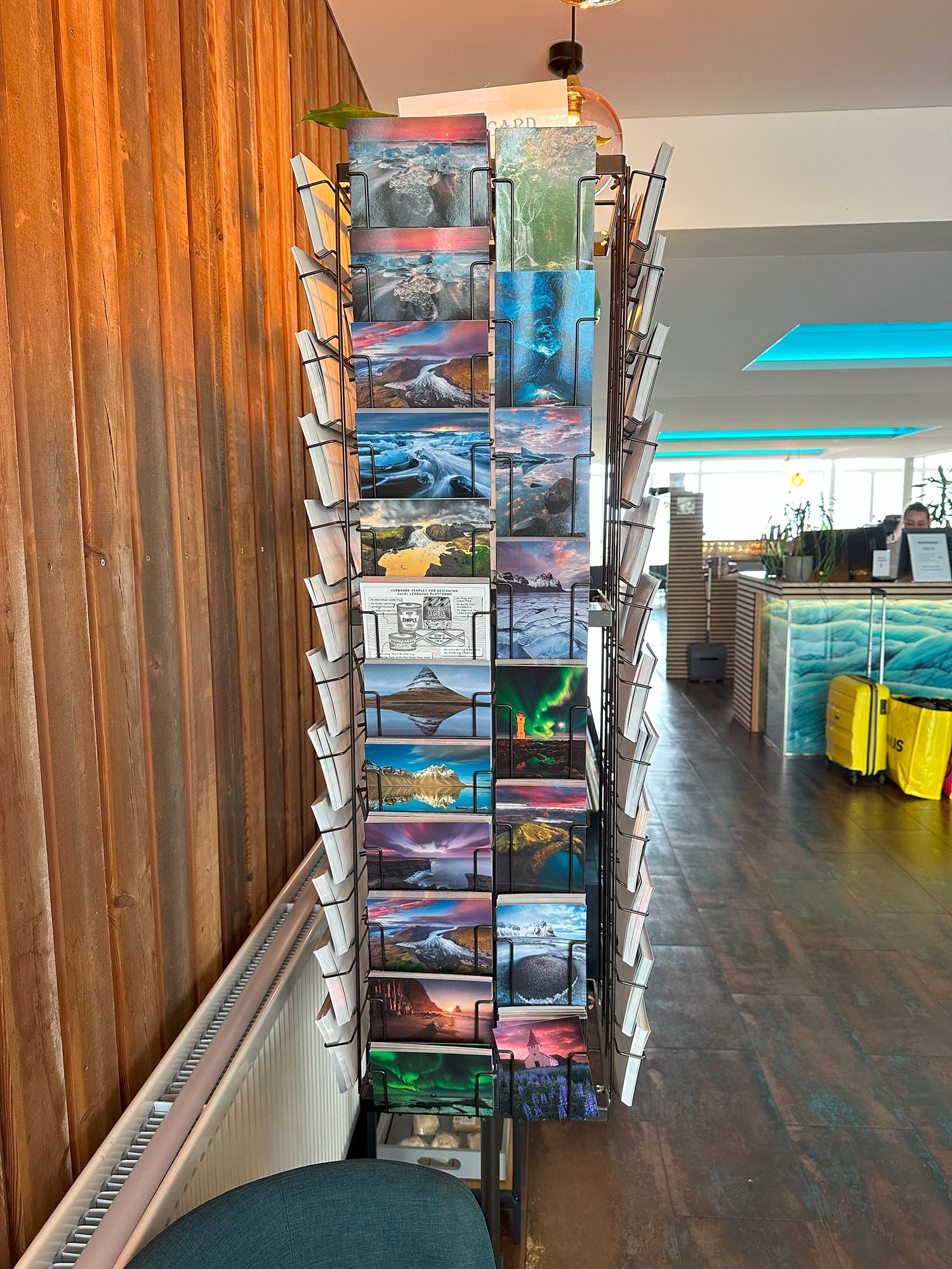A rotating rack of tourist postcards in a café